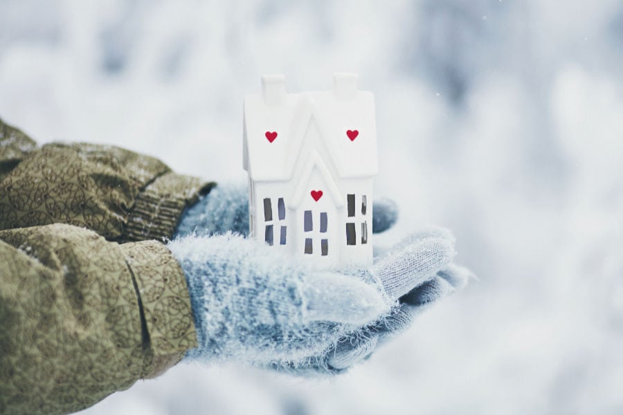 Gloved hands holding a small white bird house in Philpot, Kentucky.