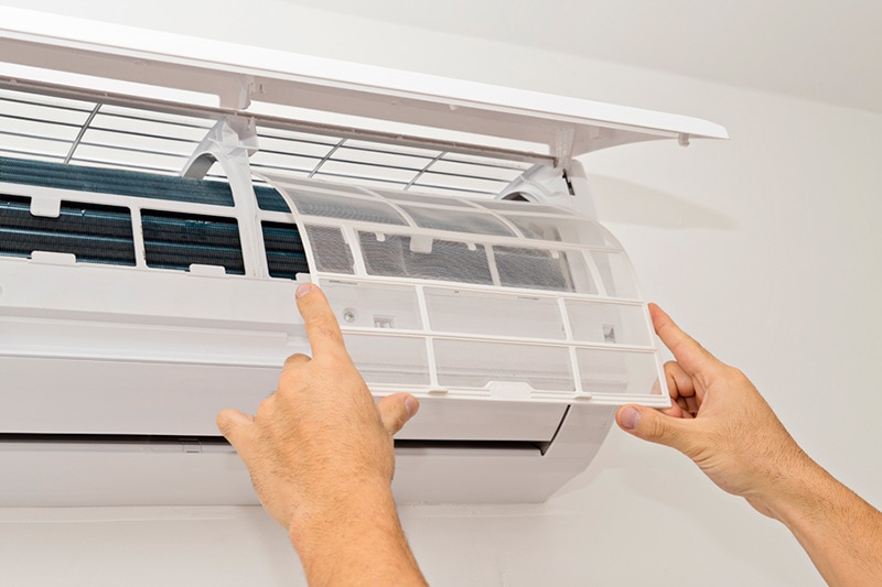 Hands opening the panel of a ductless system | What Maintenance is Needed for a Ductless System | Owensboro, KY
