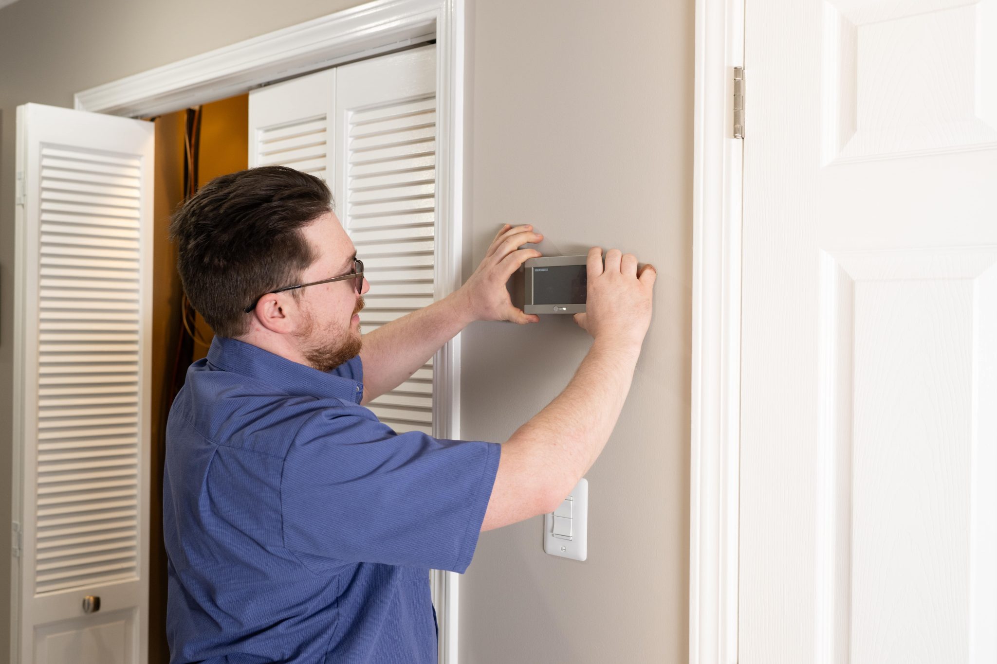 man setting thermostat