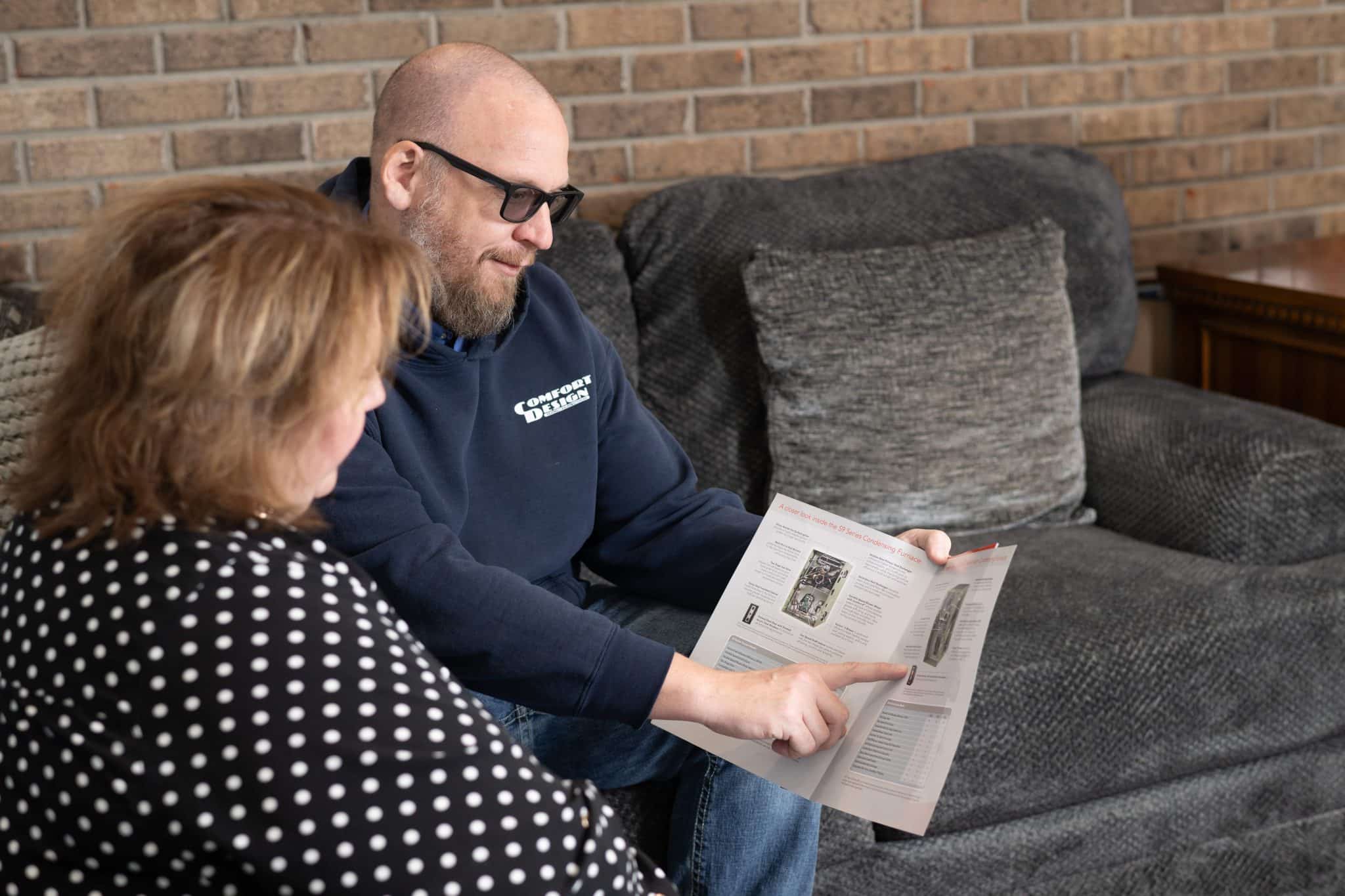 man showing a woman information in a book